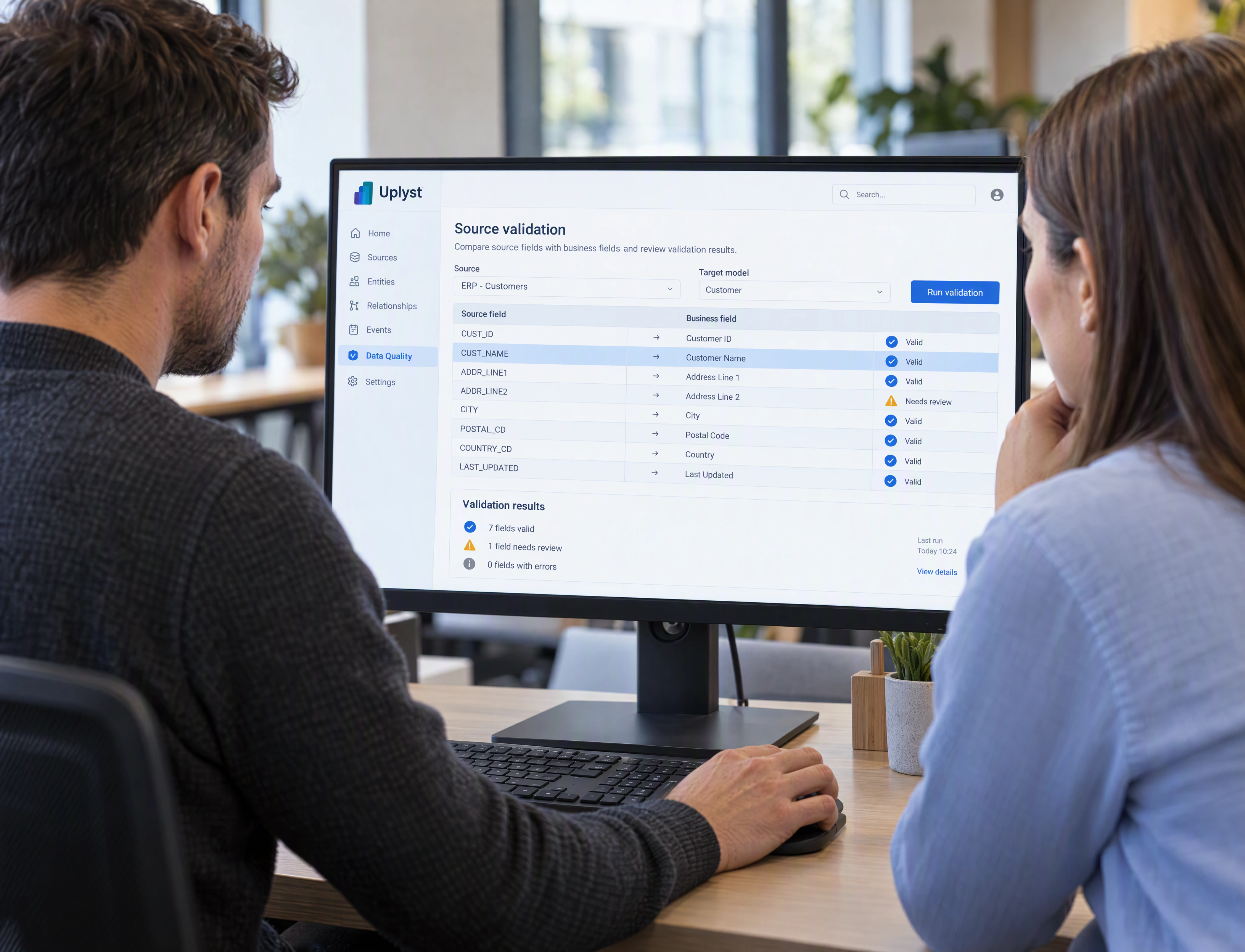 Two specialists review the source fields and validation records for an integration together.