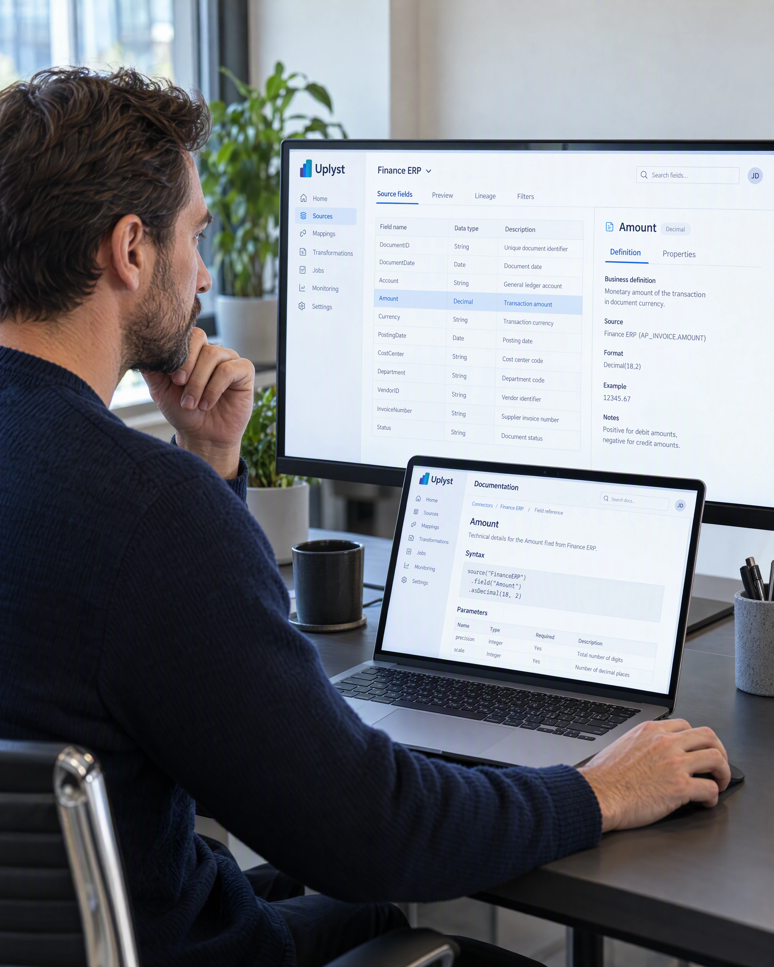 An integration engineer checks a digital reference beside a source mapping workspace.