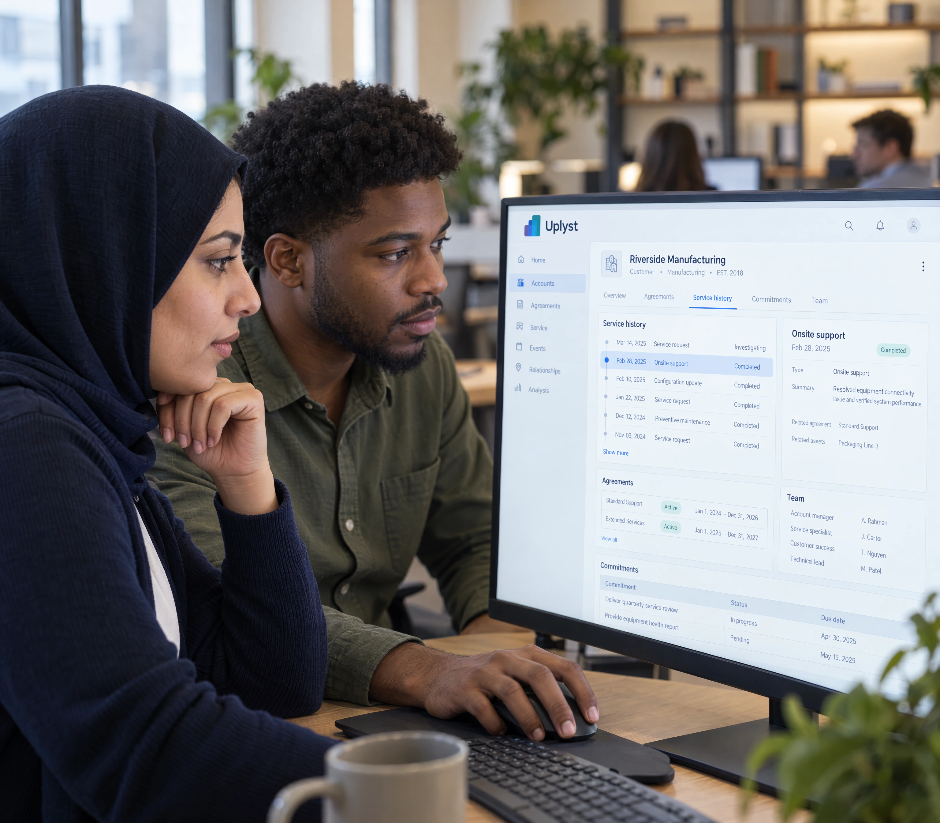 An account manager and service specialist review a customer's agreements and service history together