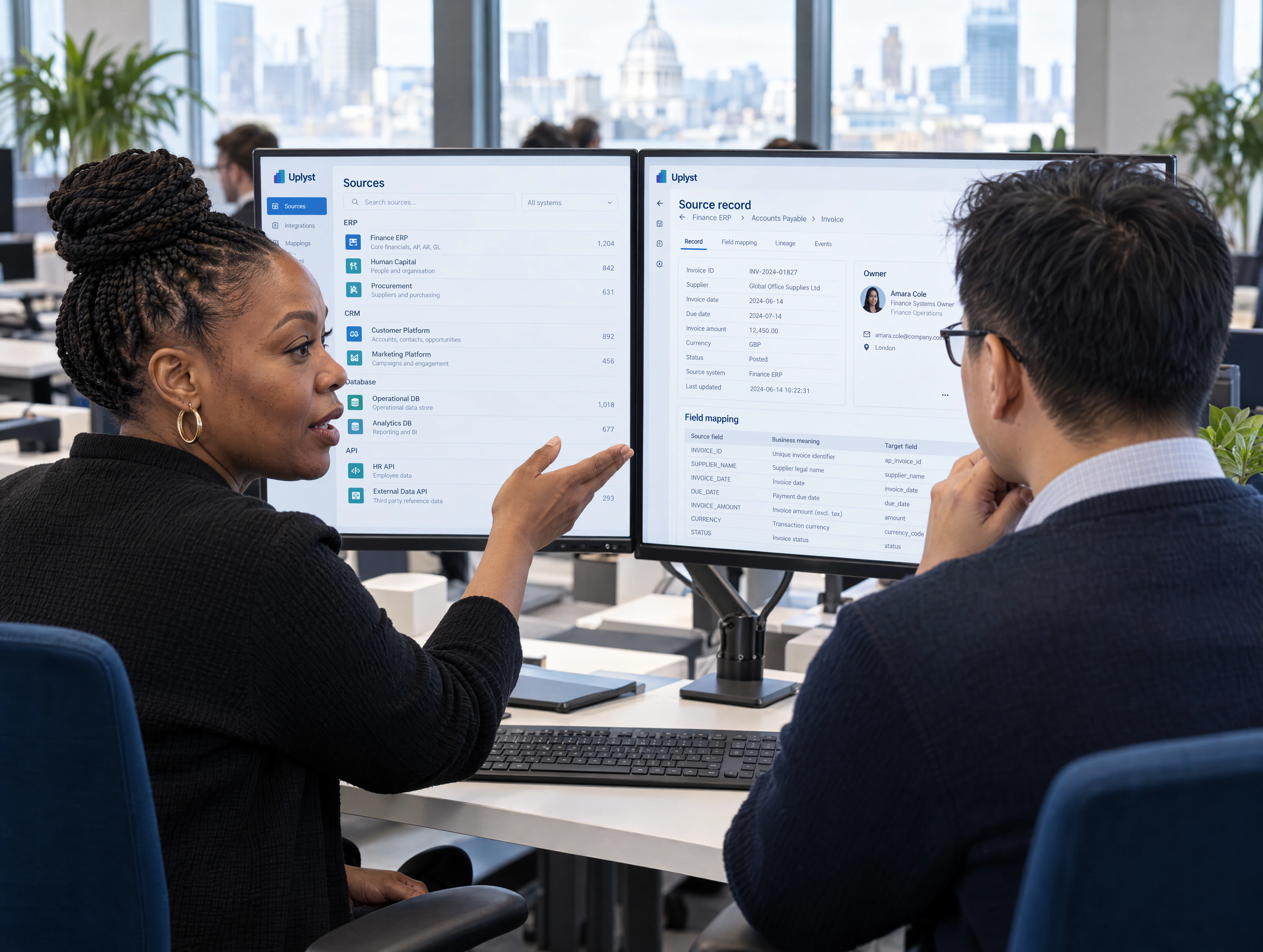 A finance systems owner and an integration engineer review the same source records at a shared workstation.