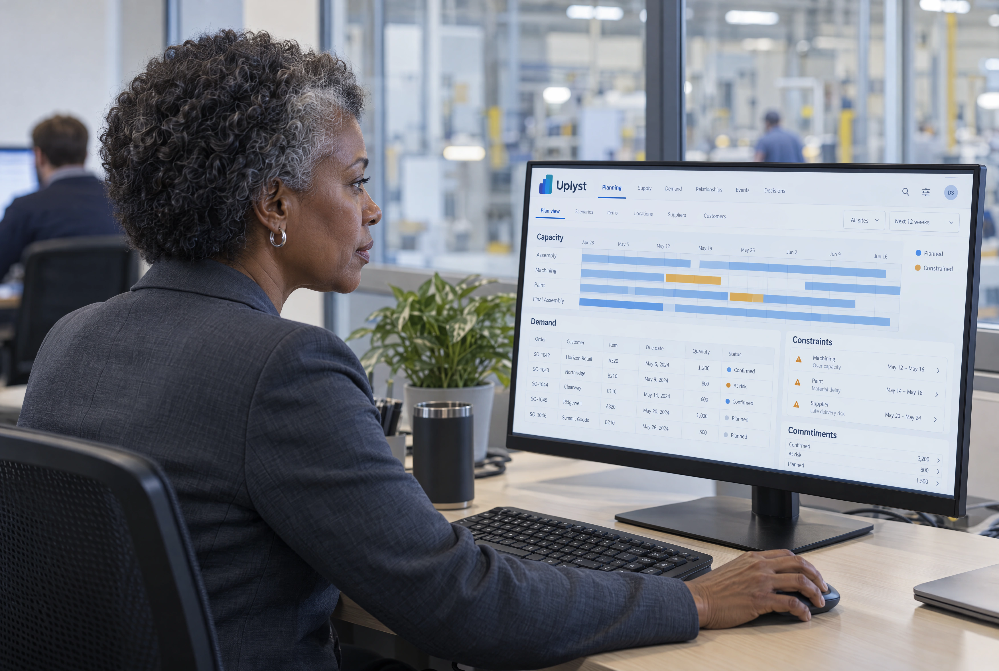 A production planning lead reviews capacity and customer demand in an enterprise planning office.