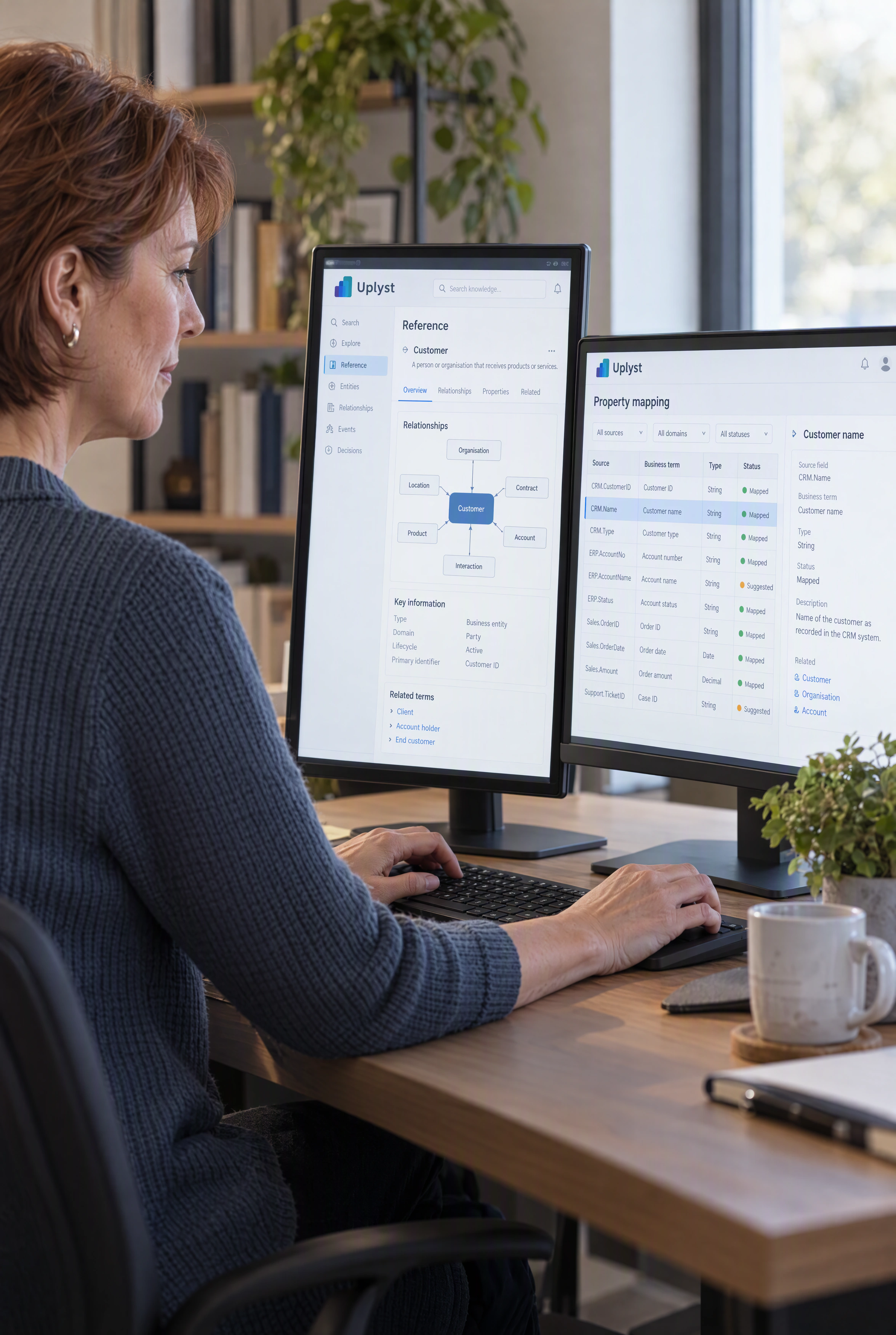 An enterprise researcher studies a business relationship model and a technical document at a workstation.