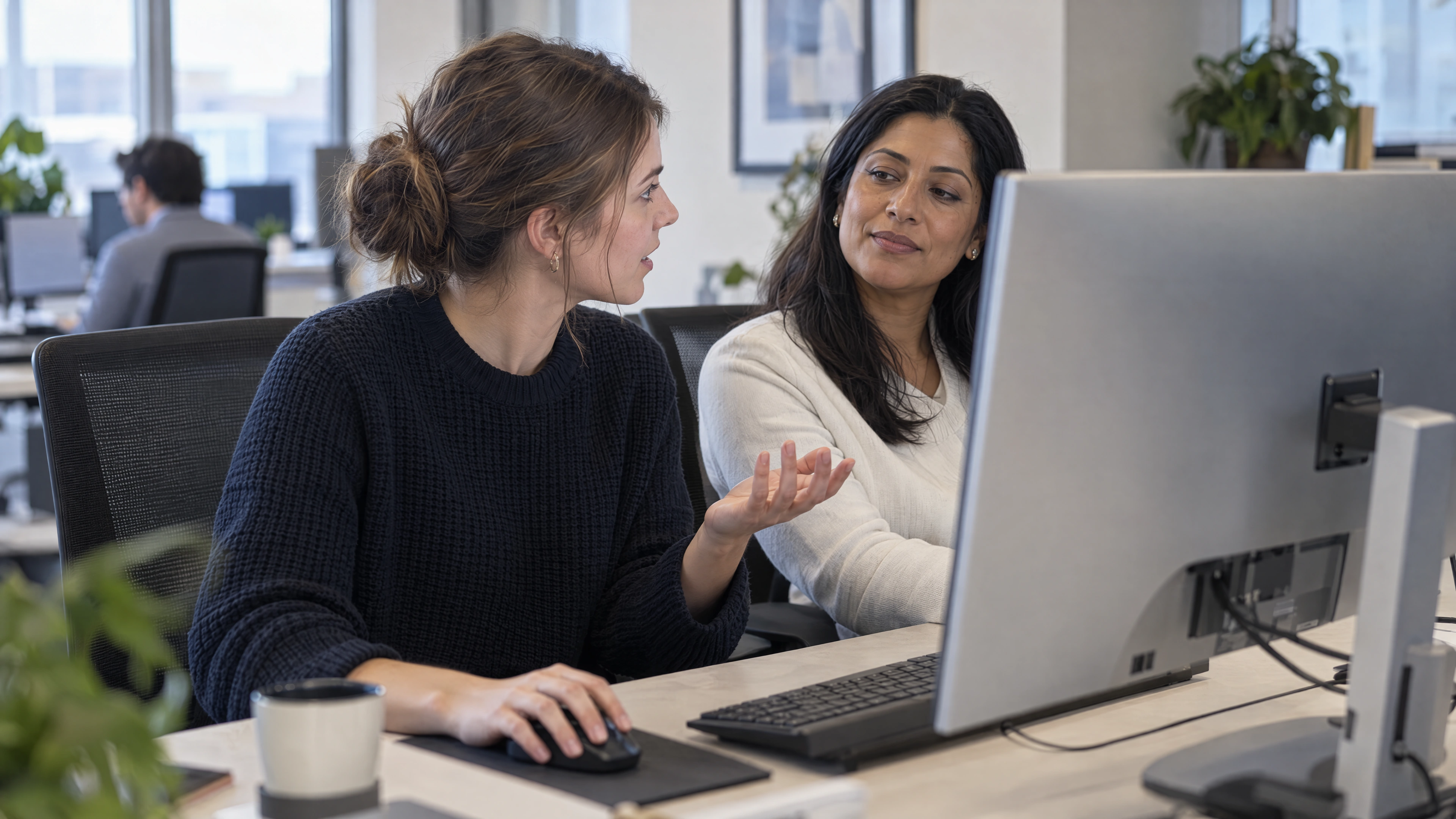 A business analyst practices reviewing an unresolved case while an experienced colleague provides support.