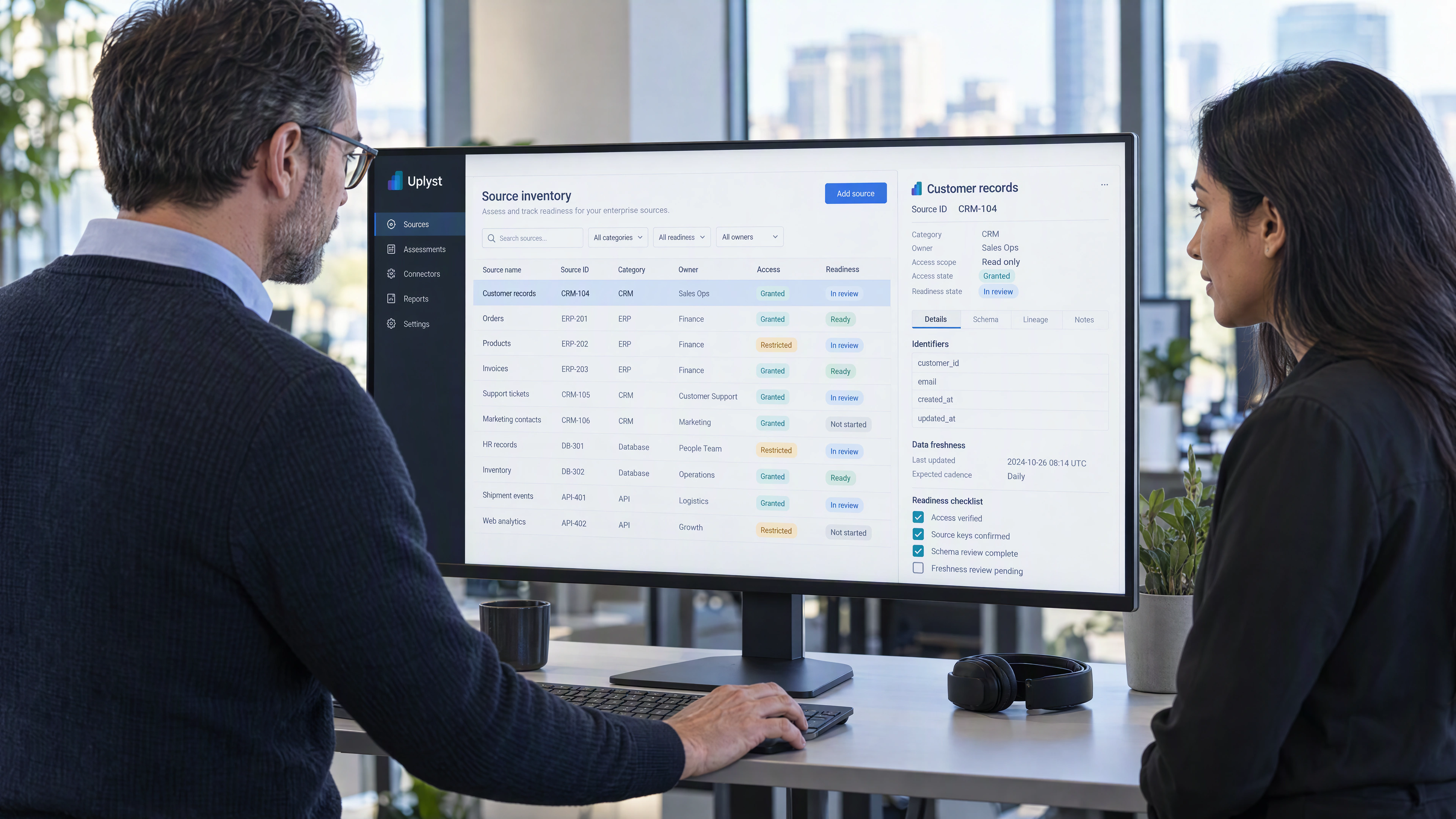 A delivery architect and source owner assess enterprise source readiness at a working software station.