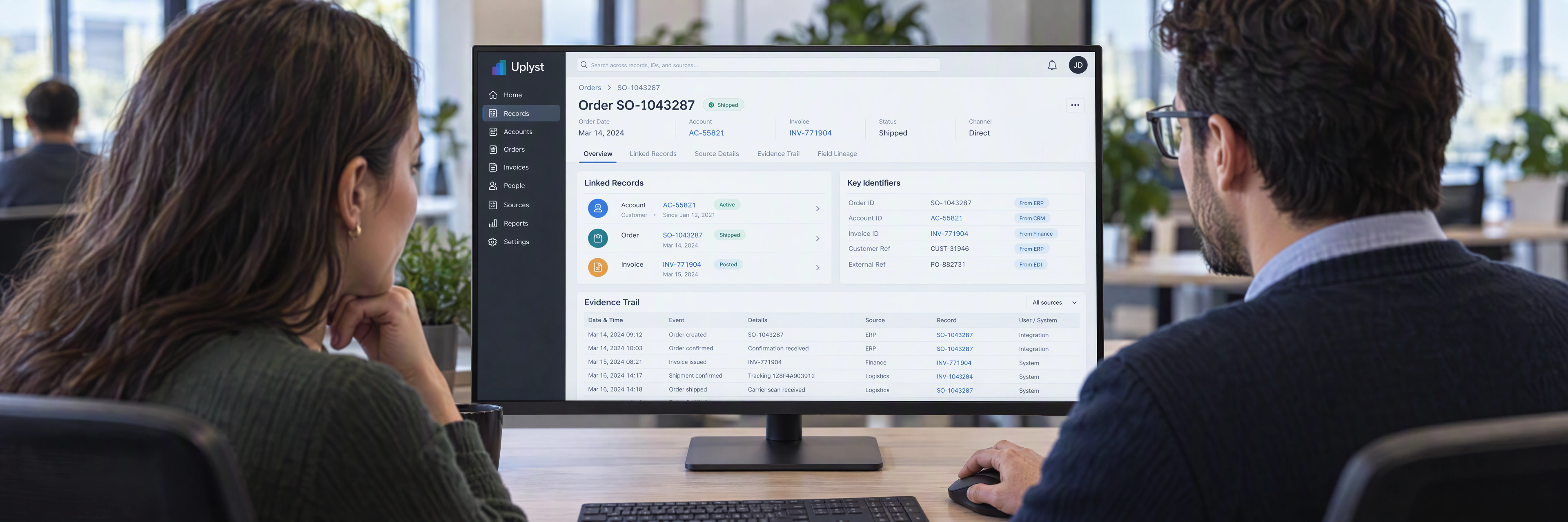 An operations analyst demonstrates the source records behind a business decision to an implementation specialist.